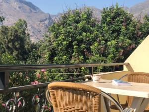 a table and chairs on a balcony with a view of mountains at Blue Sky in Frangokastello