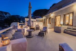 a patio with a couch and chairs and an umbrella at Hidden Treasure Suites in Vóthon