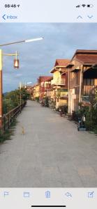 un gatto che cammina lungo una strada accanto agli edifici di Chiang Khan Riverside Pool Villa a Chiang Khan