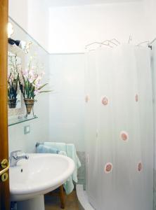 ein weißes Bad mit einem Waschbecken und einer Dusche in der Unterkunft B&B Angelide in Anacapri