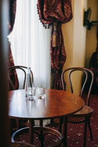 einem Holztisch mit zwei Gläsern darüber in der Unterkunft Shelter Hotel & Restaurant in Kolodezhno