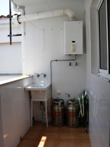 a small white bathroom with a sink and two buckets at Ayamonte Mirador in Ayamonte +30 photos