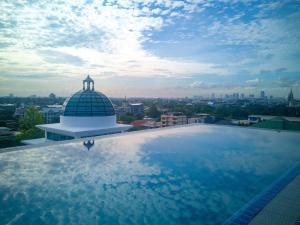 een groot zwembad op het dak van een gebouw bij Romance Hotel Sukhumvit 97 in Bangkok