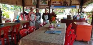 a group of three women standing at a table in a restaurant at Khim Vouch Ay Rabbit island in Kep