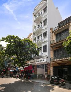 un edificio blanco alto al lado de una calle en Little Diamond Hotel, en Hanói