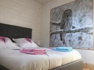 an owl is sitting on a bed in a bedroom at Les Roses Des Bois in Murat-le-Quaire
