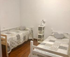 een slaapkamer met twee bedden en een lamp op een tafel bij La Casita del Centro in Vega de San Mateo +11 foto's