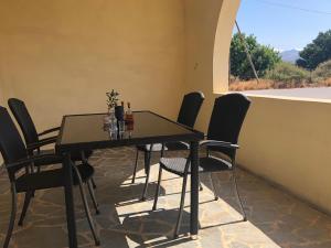 a dining room table with black chairs and a window at Blue Sky in Frangokastello