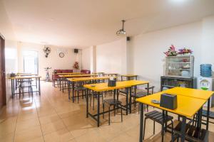 a row of tables and chairs in a restaurant at Sentosa Guest House in Pontianak
