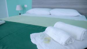 
a bed with two pillows and a towel on top of it at Naxos Laguna Beach in Giardini Naxos
