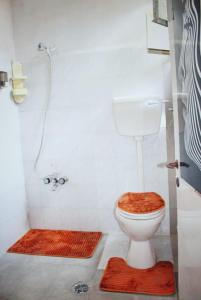 a bathroom with a toilet with a shower and mats at Friends Hostel.Area B in Hebron