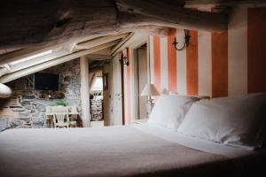 a bedroom with a bed and a stone wall at Regina Teodolinda Suites in Laglio +76 photos