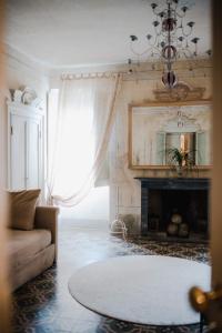 Regina Teodolinda Suites في لاليو: غرفة معيشة مع أريكة ومدفأة