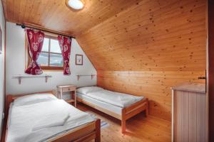 a room with two beds in a wooden cabin at Liptovské Chaty in Liptovský Mikuláš