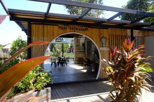 a wooden building with an archway in a yard at Awana Villa Resort Yaonoi - SHA Extra Plus in Ko Yao Noi