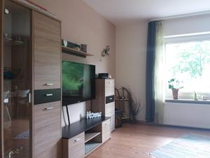 ein Wohnzimmer mit einem TV und einem Entertainment-Center in der Unterkunft Ferienwohnung Falke in Schmallenberg