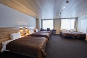 a hotel room with three beds in a room at Izumisano Center Hotel Kansai International Airport in Izumi-Sano