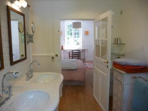 a bathroom with two sinks and a room with a bed at Le clos du Ru in Presnoy