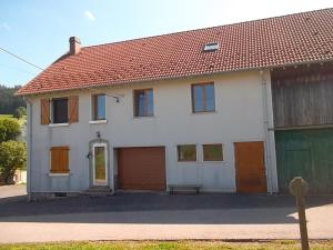 a white house with a bench in front of it at gîte 8 personnes " LE CHAMOIS " in Gerbépal
