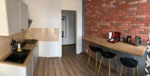 a kitchen with a counter and a brick wall at Apartament Równa 12 in Kielce +2 photos