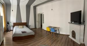 a bedroom with a bed and a table and a tv at Apartament Równa 12 in Kielce