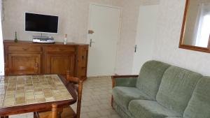 a living room with a couch and a table and a tv at PIED A TERRE 4 in Amélie-les-Bains-Palalda