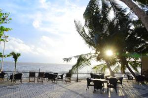 a patio with tables and chairs next to the ocean at Hotel Leaf on Lagoon in Katunayaka