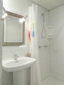 a bathroom with a sink and a shower with a mirror at www Parques de la Catedral travel com Parking privado Gratis in León
