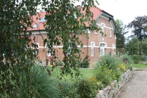 ein Backsteingebäude mit einem Garten davor in der Unterkunft Storchenhof in Eutin