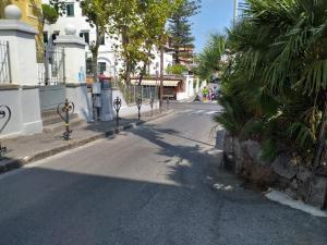 een lege straat met palmbomen aan de kant van de weg bij Appartamento g. Cervera66 in Ischia