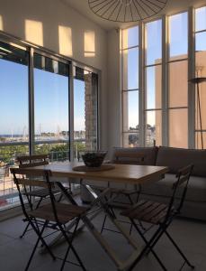 a table and chairs in a living room with a couch at Bandol, vue panoramique sur la mer, la plage, le port in Bandol