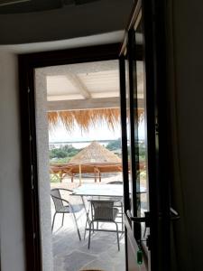 Blick auf eine Terrasse mit einem Tisch und Stühlen in der Unterkunft Agriturismo Dolceluna Le Capanne in Muravera