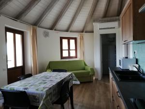 a living room with a green couch and a table at Agriturismo Dolceluna Le Capanne in Muravera
