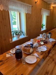 a wooden table with plates of food on it at Tooraku Turismitalu in Pusku