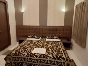 
a hotel room with a bed and two lamps at Hotel Alka in Varanasi
