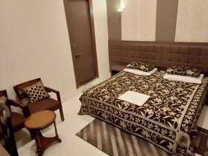 
a hotel room with a bed, chair, and table at Hotel Alka in Varanasi
