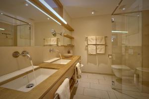 a bathroom with a sink and a shower and a toilet at Zur Post Residence Sexten in Sesto