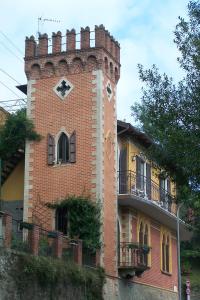 un bâtiment en brique avec une tour d'horloge en haut. dans l'établissement B&B Torre Lara, à Belgirate