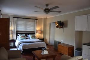 a bedroom with a bed and a ceiling fan at Robin's Nest in Hermanus