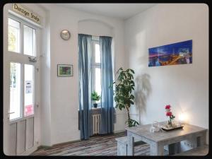 a living room with a table and a window and a clock at Hostel 199 in Berlin