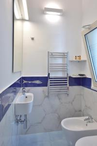 La salle de bains blanche est pourvue d'un lavabo et d'un miroir. dans l'établissement Casa Amorino, à Minori