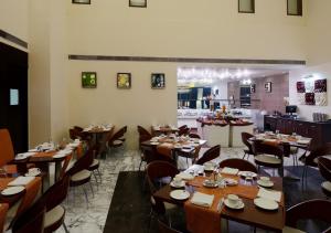 a dining room with wooden tables and chairs at Hotel DS Clarks Inn Gurgaon in Gurgaon