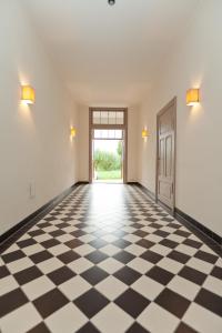 un couloir vide avec un sol en damier noir et blanc dans l'établissement Gutshaus Lexow, à Lexow
