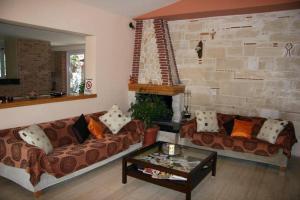 a living room with two couches and a table at Daniel Hotel in Kalamaki