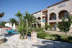 a building with palm trees next to a resort at Daniel Hotel in Kalamaki