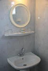 a bathroom with a sink and a mirror on the wall at Daniel Hotel in Kalamaki