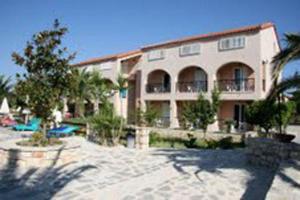 a large building with a swimming pool in front of it at Daniel Hotel in Kalamaki