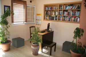 an office with a desk and potted plants at Daniel Hotel in Kalamaki