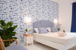 ein Schlafzimmer mit einem Bett mit blauen und weißen Tapeten in der Unterkunft Pezz Pezz in Praiano