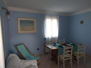 uma sala de jantar com paredes azuis e uma mesa e cadeiras em Lavanda em Torre del Lago Puccini